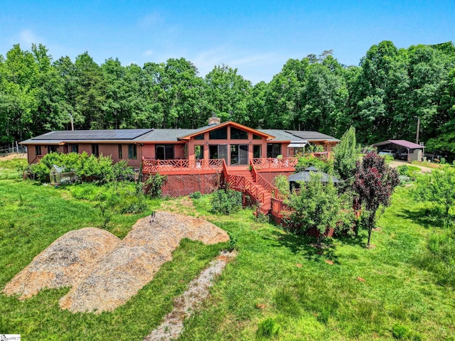 313 Viewmont Dr, Greenville, SC 29609 - view of front facade featuring a wooden deck, a chimney, roof mounted solar panels, and a front lawn