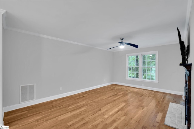 unfurnished living room featuring baseboards, ornamental molding, a ceiling fan, and light wood-style flooring