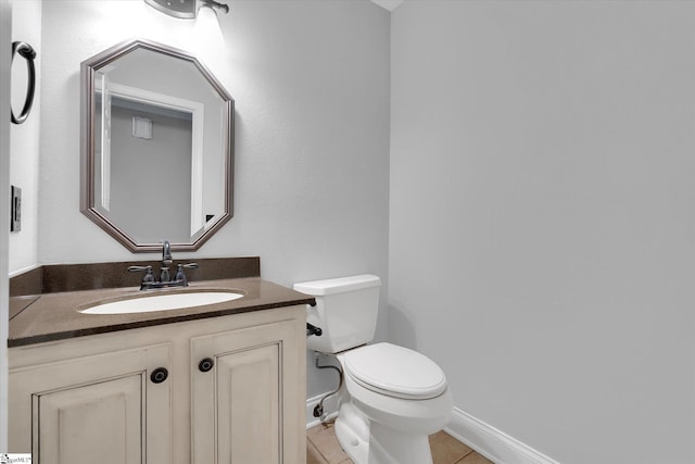 bathroom featuring tile patterned flooring, toilet, vanity, and baseboards