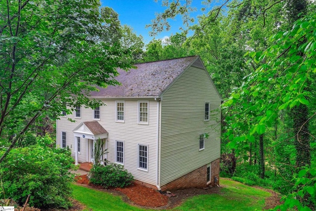 colonial-style house featuring roof with shingles