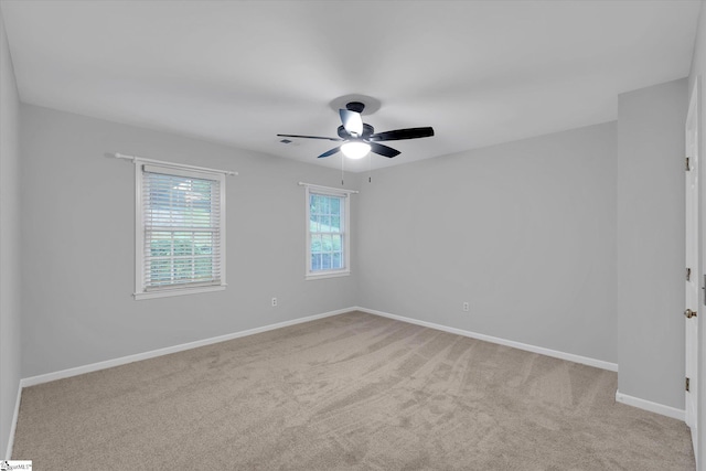 unfurnished room with ceiling fan, light colored carpet, and baseboards