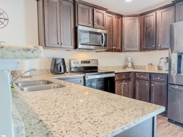 128 Adger Rd, Pendleton, SC 20670 - kitchen featuring appliances with stainless steel finishes, a sink, dark brown cabinets, light stone countertops, and light wood-style floors