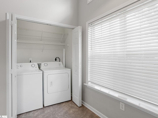 clothes washing area with washing machine and dryer and baseboards