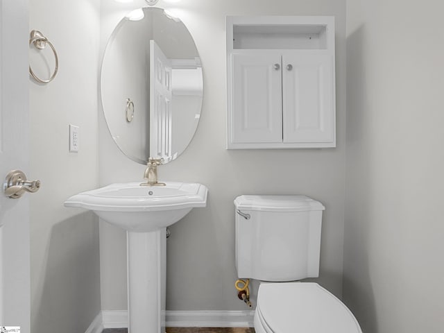 half bathroom with toilet and baseboards