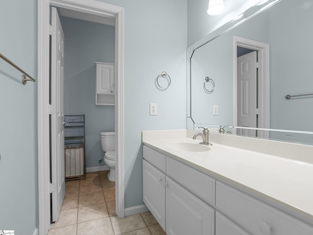 bathroom featuring toilet, vanity, tile patterned floors, and baseboards