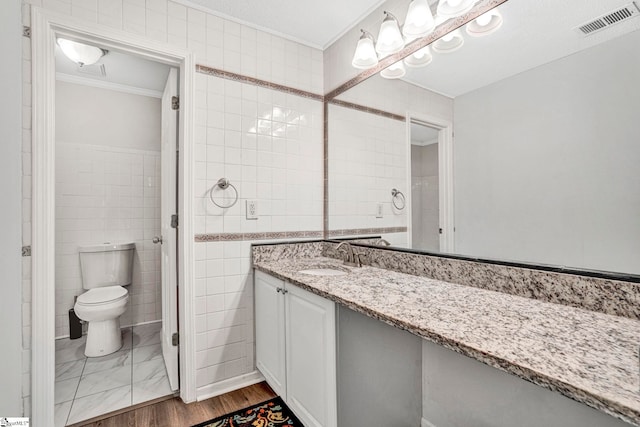 1105 Autumn Leaf Ln, Fountain Inn, SC 29644 - bathroom featuring ornamental molding, toilet, vanity, and tile walls
