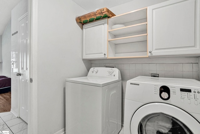 1105 Autumn Leaf Ln, Fountain Inn, SC 29644 - clothes washing area with washing machine and dryer, cabinet space, marble look tiles, and baseboards