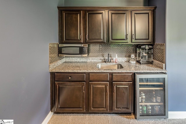 112 Murdock Ln, Greer, SC 29651 - kitchen featuring wine cooler, a sink, stainless steel microwave, dark brown cabinets, and backsplash
