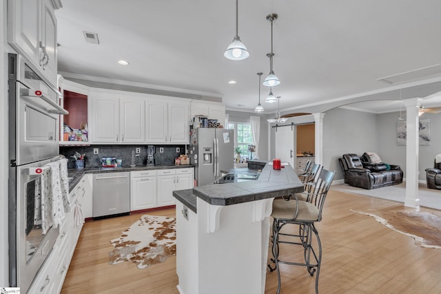 317 Hunter Rd, Fountain Inn, SC 29644 - kitchen with decorative columns, stainless steel appliances, a center island, ornamental molding, and a breakfast bar