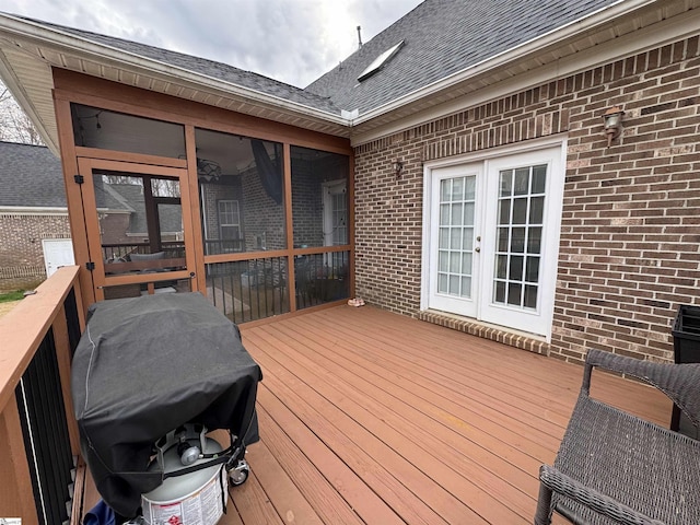 wooden terrace featuring french doors, grilling area, and a sunroom