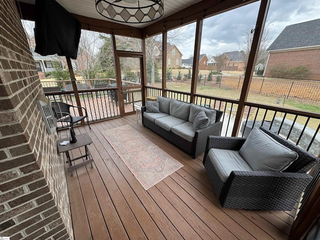sunroom with outdoor lounge area, a residential view, and ceiling fan