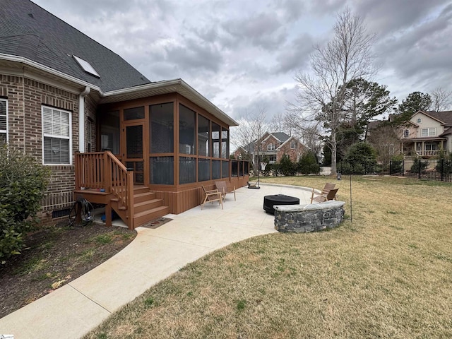 view of side of property with a sunroom, a patio, a lawn, a shingled roof, and brick siding