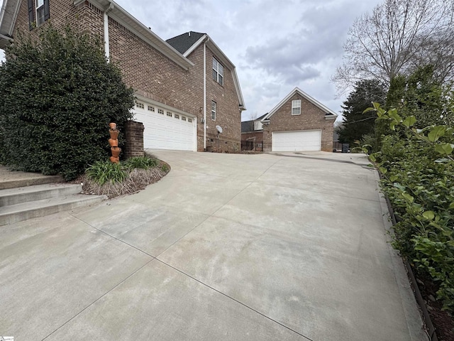 view of side of home featuring brick siding and driveway
