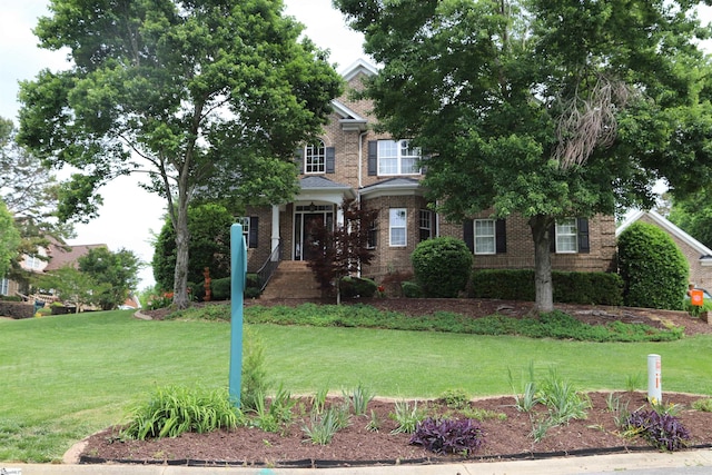 view of front of property featuring brick siding and a front yard