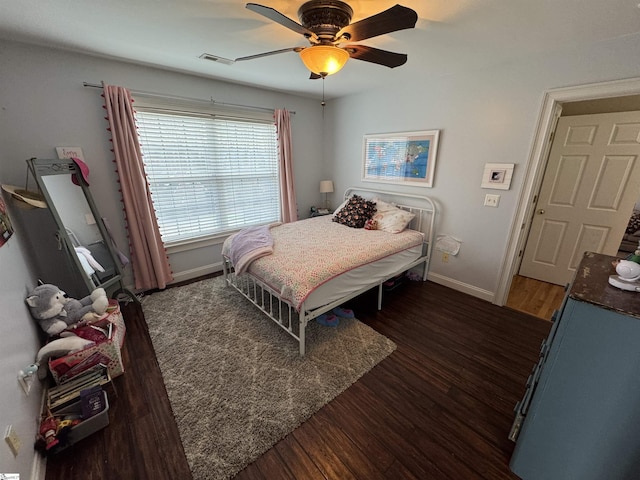 bedroom featuring baseboards, wood finished floors, and ceiling fan