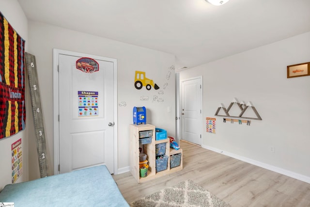 bedroom with light wood finished floors and baseboards