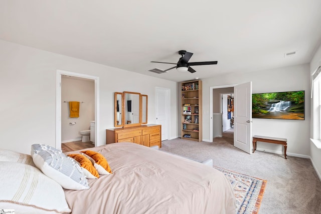 bedroom featuring baseboards, light colored carpet, connected bathroom, and a ceiling fan