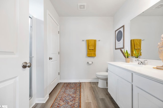 full bath featuring wood finished floors, vanity, toilet, and baseboards
