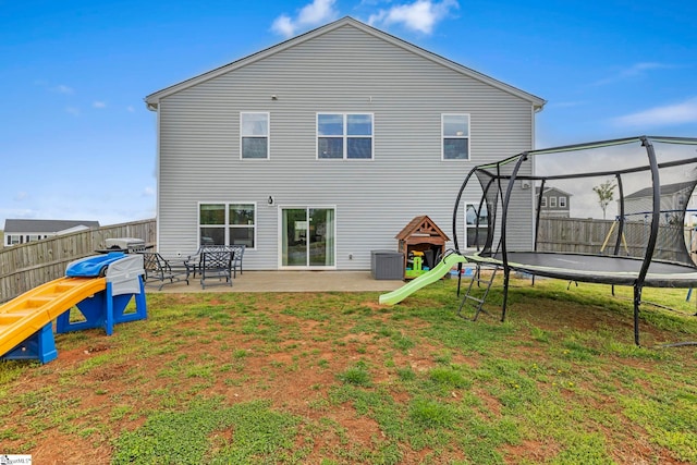 back of property with a trampoline, a patio area, and central AC unit