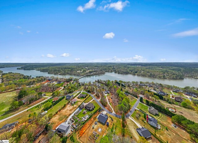 aerial overview of property's location with a large body of water and a heavily wooded area