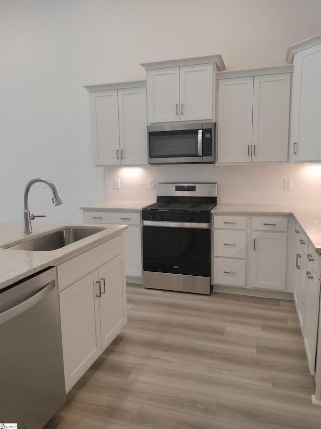 234 Woodhouse Way # 1, Greenville, SC 29605 - kitchen with stainless steel appliances, a sink, tasteful backsplash, light wood-style flooring, and white cabinetry