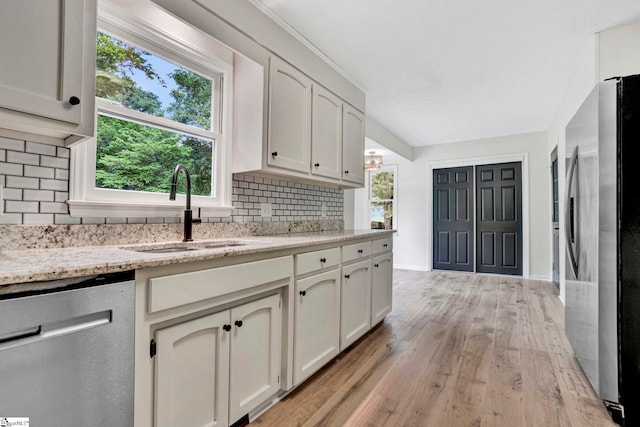 167 Lake Bowen Dr, Inman, SC 29349 - kitchen featuring appliances with stainless steel finishes, a sink, backsplash, light wood-type flooring, and plenty of natural light