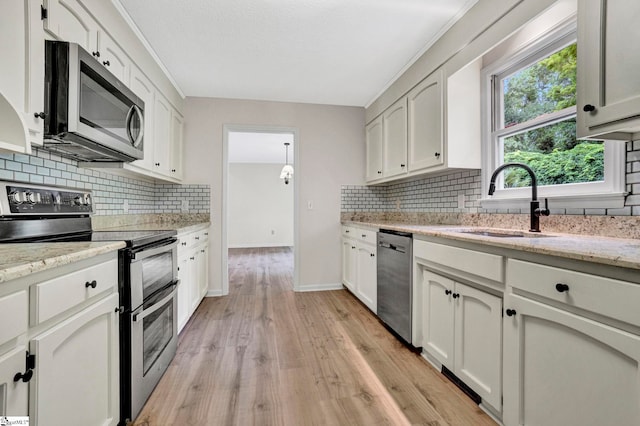 167 Lake Bowen Dr, Inman, SC 29349 - kitchen featuring appliances with stainless steel finishes, a sink, decorative backsplash, light wood-style floors, and white cabinets