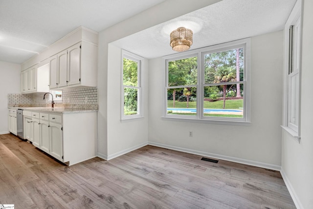 167 Lake Bowen Dr, Inman, SC 29349 - kitchen featuring dishwasher, backsplash, white cabinetry, light wood-style flooring, and baseboards