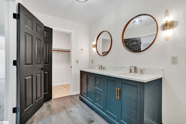 167 Lake Bowen Dr, Inman, SC 29349 - bathroom featuring a textured ceiling, double vanity, baseboards, and a walk in closet