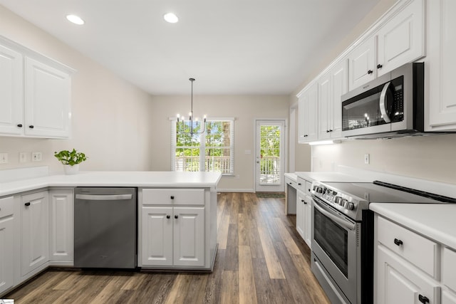kitchen featuring appliances with stainless steel finishes, a peninsula, dark wood finished floors, white cabinets, and recessed lighting