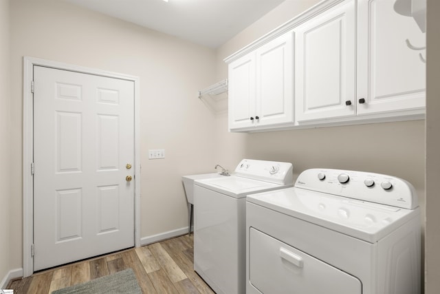 laundry room featuring cabinet space, washing machine and clothes dryer, light wood finished floors, and baseboards