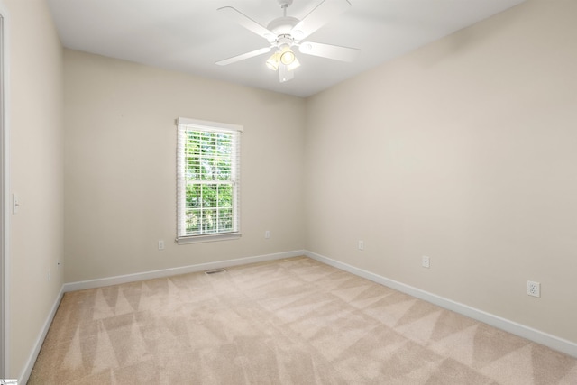 unfurnished room featuring light colored carpet, baseboards, and ceiling fan