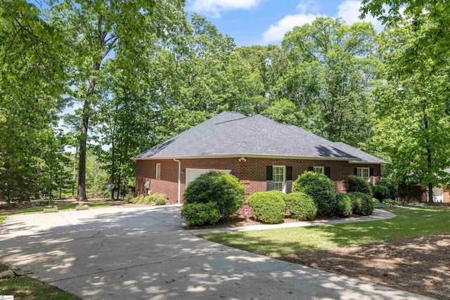 view of side of home featuring brick siding, concrete driveway, a garage, and a shingled roof