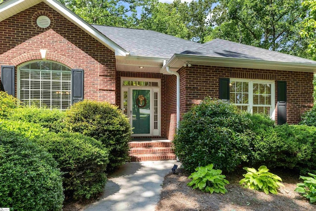 view of front of property with brick siding and roof with shingles