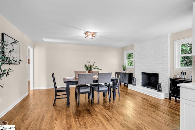203 Homestead Dr, Taylors, SC 29687 - dining area with light wood-style floors, baseboards, and a brick fireplace