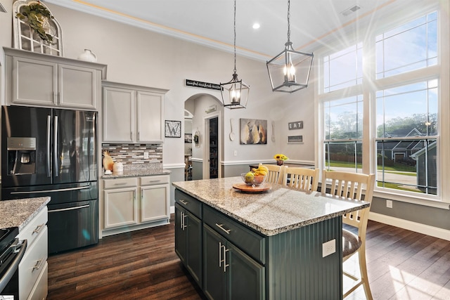 406 Jersey Queen Trl, Greer, SC 29651 - kitchen with refrigerator with ice dispenser, arched walkways, tasteful backsplash, dark wood-style flooring, and a breakfast bar area