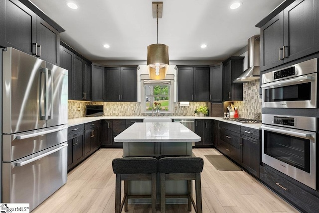 5 Maxfli Ct, Greenville, SC 29690 - kitchen with stainless steel appliances, wall chimney exhaust hood, light wood-type flooring, recessed lighting, and decorative backsplash