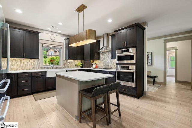 5 Maxfli Ct, Greenville, SC 29690 - kitchen featuring wall chimney range hood, a sink, light countertops, light wood-type flooring, and recessed lighting