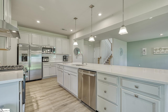 1128 Grovewood Ct, Moore, SC 29369 - kitchen with stainless steel appliances, a sink, white cabinets, backsplash, and light wood-type flooring
