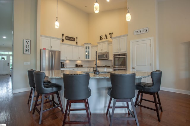 250 Chickadee Trl, Easley, SC 29642 - kitchen featuring appliances with stainless steel finishes, a high ceiling, baseboards, white cabinetry, and dark wood-style floors