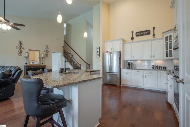 250 Chickadee Trl, Easley, SC 29642 - kitchen with freestanding refrigerator, high vaulted ceiling, backsplash, open floor plan, and light stone counters