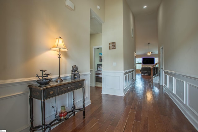250 Chickadee Trl, Easley, SC 29642 - hall featuring dark wood-style floors, a high ceiling, wainscoting, and a decorative wall