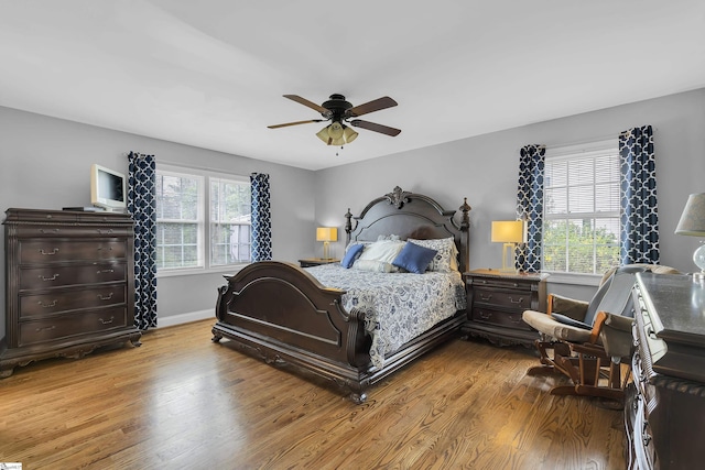 bedroom featuring wood finished floors, baseboards, and a ceiling fan