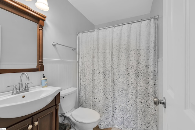 bathroom featuring wainscoting, toilet, vanity, and a shower with shower curtain