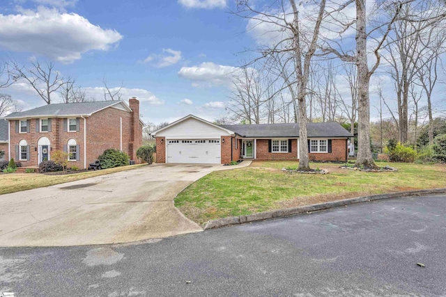 view of front of property featuring brick siding, a garage, driveway, and a front lawn