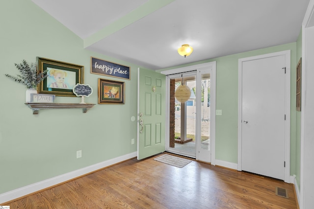foyer entrance with wood finished floors and baseboards