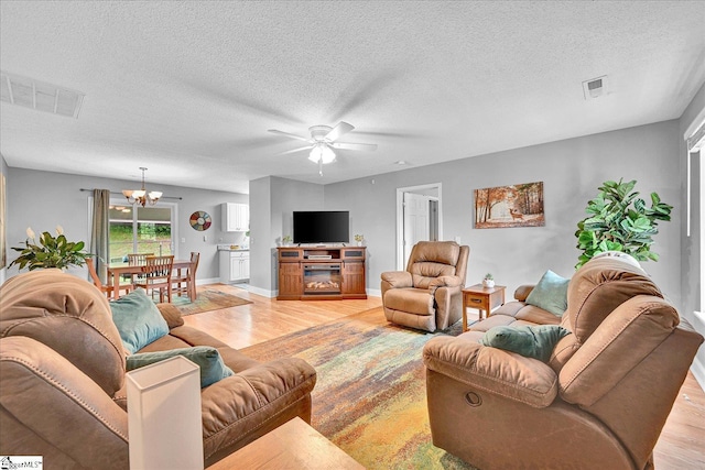 205 Willow Leaf Dr, Seneca, SC 29672 - living area with light wood-style flooring, a chandelier, a textured ceiling, a ceiling fan, and baseboards