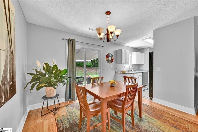 205 Willow Leaf Dr, Seneca, SC 29672 - dining space with a chandelier, light wood-type flooring, baseboards, and a textured ceiling