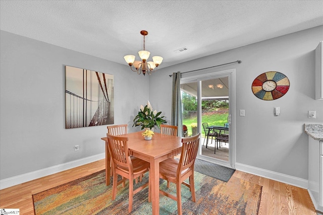 205 Willow Leaf Dr, Seneca, SC 29672 - dining room with a chandelier, light wood-type flooring, baseboards, and a textured ceiling