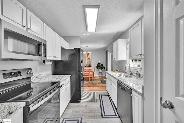 205 Willow Leaf Dr, Seneca, SC 29672 - kitchen with appliances with stainless steel finishes, a sink, white cabinets, light wood finished floors, and light stone counters